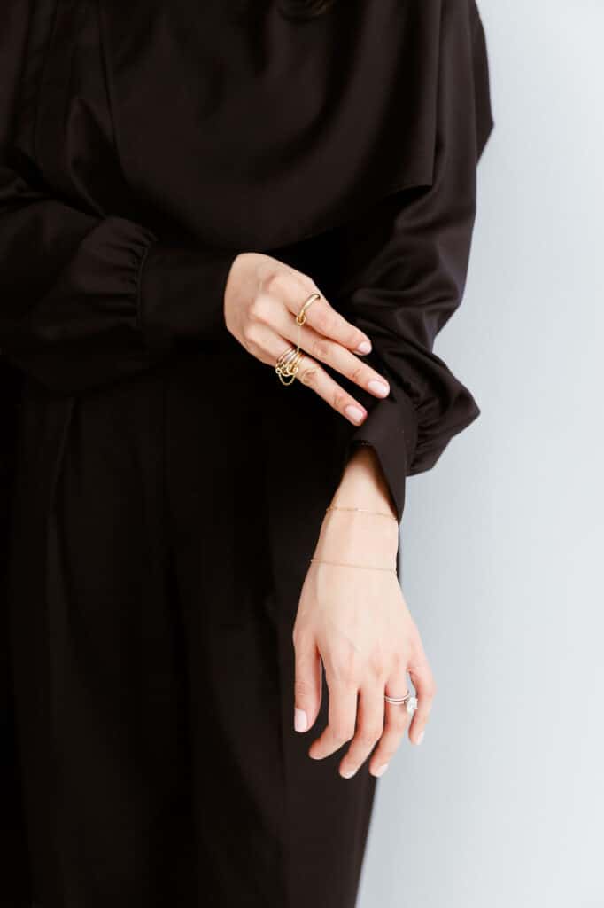 Woman dressed in black wearing gold accessories.
