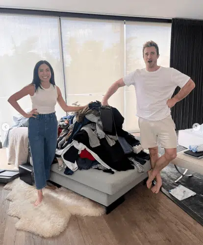 Matthew and Cassandra next to a pile of clothes 