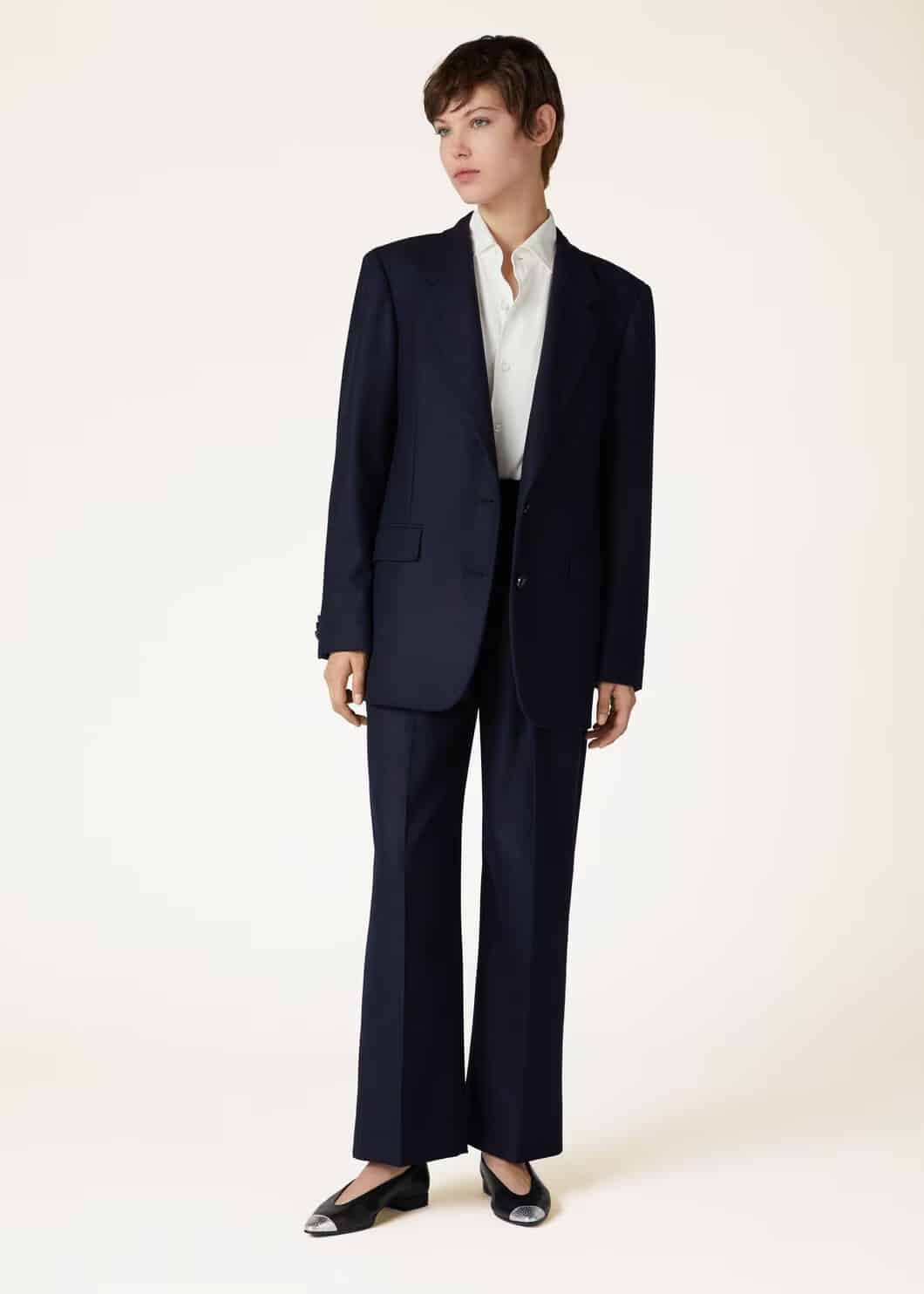 A woman dressed in classic power suit workwear.